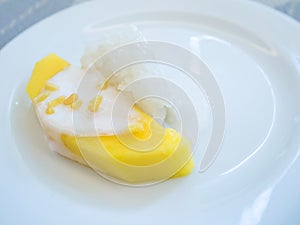 sweet mango with sticky rice with coconut milk on white plate