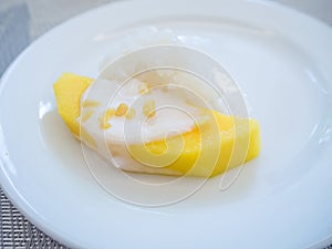 sweet mango with sticky rice with coconut milk on white plate