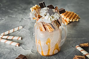 Sweet milkshake drink with dripping sauce, cream, cake and chocolate