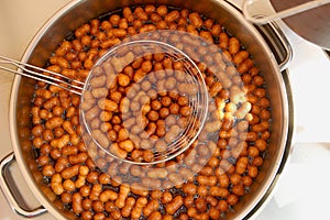 Sweet mini donuts frying in oil.