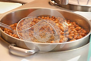 Sweet mini donuts frying in oil.