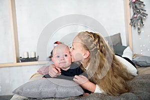 Sweet moment between a big sister and her baby brother. The sister is kissing his cheek. Love sisters. parental care and