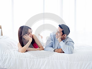 The sweet moment of happy couple lying on the white bed.