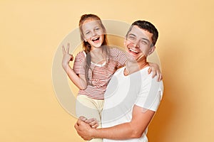 Sweet moments of fatherhood, happy laughing father holding embrace cute little child daughter, smiling daddy and small kid with v