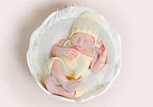 Sweet newborn baby in hat and panties sleeping on the shell