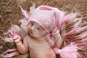 Sweet newborn baby in pink cap open eyes, wakes