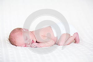 Sweet newborn baby sleeping wearing a diaper