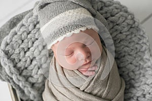 Sweet newborn baby sleeps in a basket. Beautiful newborn boy