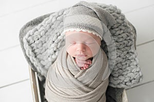 Sweet newborn baby sleeps in a basket. Beautiful newborn boy