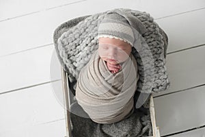 Sweet newborn baby sleeps in a basket. Beautiful newborn boy