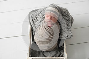 Sweet newborn baby sleeps in a basket. Beautiful newborn boy