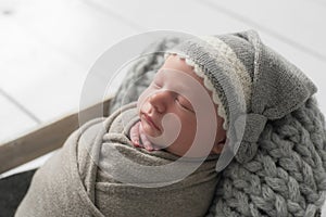 Sweet newborn baby sleeps in a basket. Beautiful newborn boy