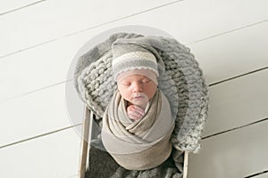 Sweet newborn baby sleeps in a basket. Beautiful newborn boy
