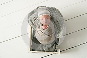 Sweet newborn baby sleeps in a basket. Beautiful newborn boy