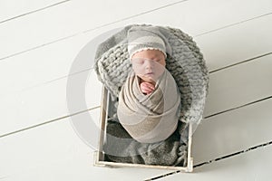 Sweet newborn baby sleeps in a basket. Beautiful newborn boy