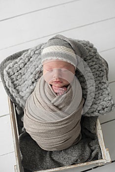 Sweet newborn baby sleeps in a basket. Beautiful newborn boy