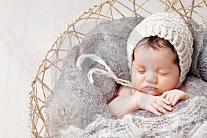 Sweet newborn baby sleeps in a basket. Beautiful newborn boy with bear toy. Happy family