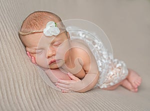 Sweet newborn girl sleeping on her hand