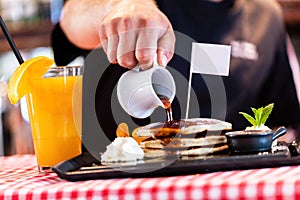 Sweet pancakes dripped with maple syrup in american restaurant photo