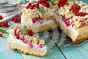 Sweet pastries. Cupcake with Pavlov meringue and fresh summer red currants on the kitchen wooden table.