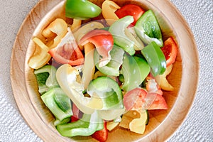 Sweet Pepper Cutting Sliced Preparation for Cooking. Raw Variety Red, Green, Yellow Sweet Peppers Slicing Chopped in Wooden Bowl