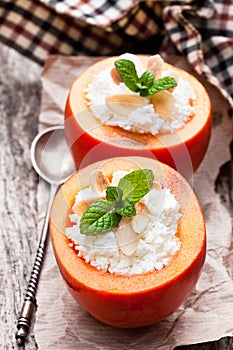 Sweet persimmons stuffed with cottage cheese and almonds on woo