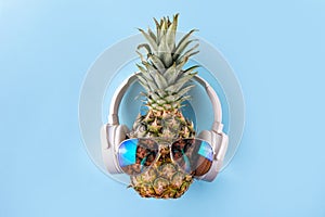 Sweet pineapple in sunglasses and headphones