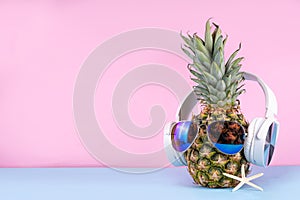 Sweet pineapple in sunglasses and headphones