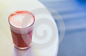 Sweet pink stawberry coffee latte with foam and coffee art on table on white background. Copy space for menu