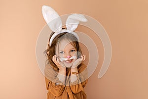 A sweet, pleasant little girl dressed up in an Easter bunny costume