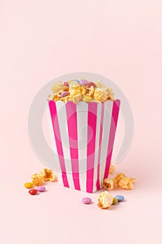 sweet popcorn with dragee on pink background