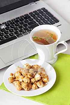 Sweet popcorn food on the table in still life tea party dessert computer, laptop, thyme