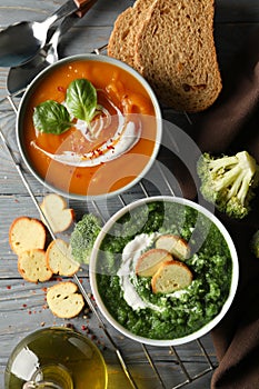 Sweet potato and broccoli cream soups on background, top view