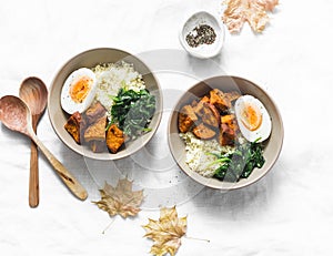 Sweet potato, couscous, spinach, egg buddha bowl on light background, top view. Vegetarian food