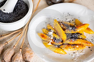Sweet potato dumpling wedges with poppy seeds, poppy heads and mortar
