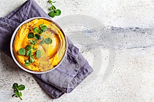 Sweet potato hummus or pumpkin dip in a gray bowl, top view