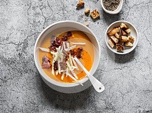 Sweet potato puree soup with crispy bacon  croutons and apple on a gray background  top view