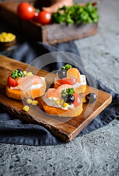 Sweet potato slices topped with cream cheese, smoked salmon, olives and corn