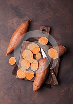 Sweet potato on wooden kitchen board from above.