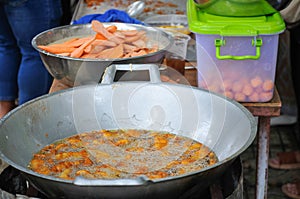 Sweet Potatoes being fried in Frying Pan with Heat Palm Oil