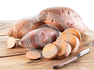 Sweet potatoes on the old wooden table.