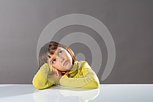 Sweet pouting thinker looking away for concept of kid boredom photo