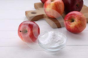 Sweet powdered fructose and fresh apples on white wooden table