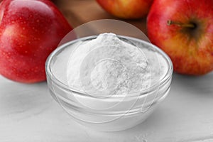 Sweet powdered fructose and fresh apples on white wooden table, closeup