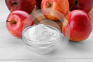 Sweet powdered fructose and fresh apples on white wooden table, closeup