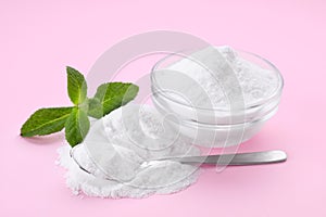 Sweet powdered fructose and mint leaves on pink background