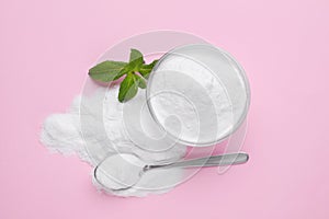 Sweet powdered fructose and mint leaves on pink background, flat lay