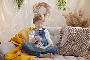 Sweet preschool boy in studio, playing with, egg for Easter and eating chocolate, child on Easter holiday