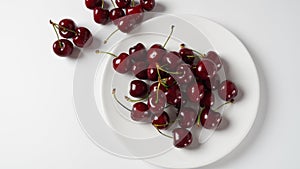 Sweet red cherries on a plate, fresh ripe sour cherries