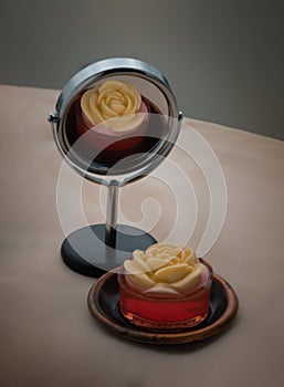 Sweet red jelly dessert layered with rose petal-shaped topping design with romantic pink tone background